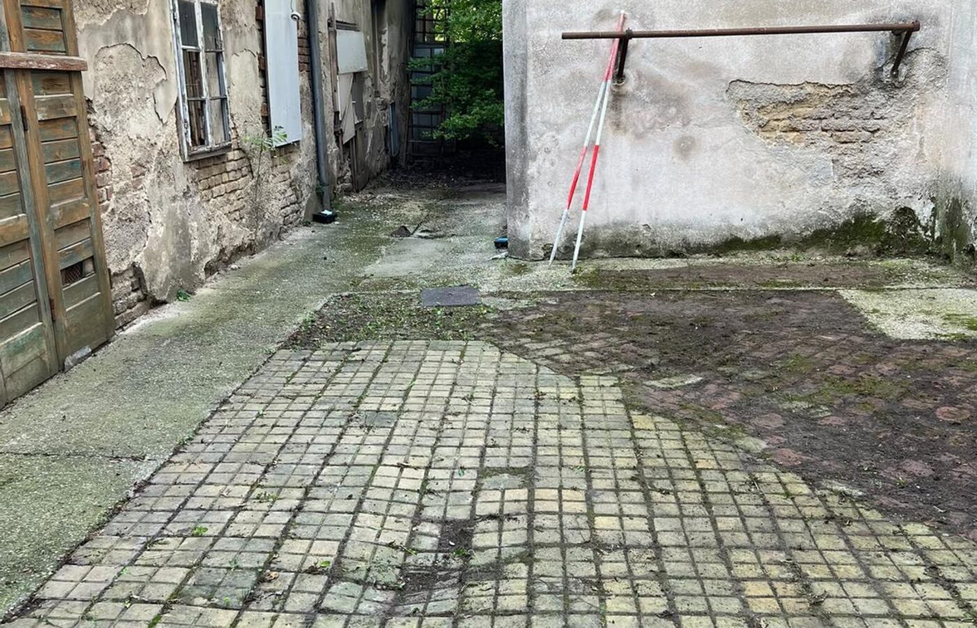 Nachher-Aufnahme: derselbe Innenhof mit freigelegtem Pflaster